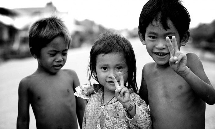 Young children making the peace sign with their hands