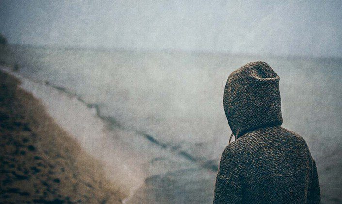 Girl with a hood on staring into the distance