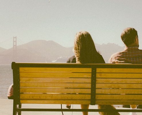 Couple sitting on a bench looking at the Golden Gate Bridge