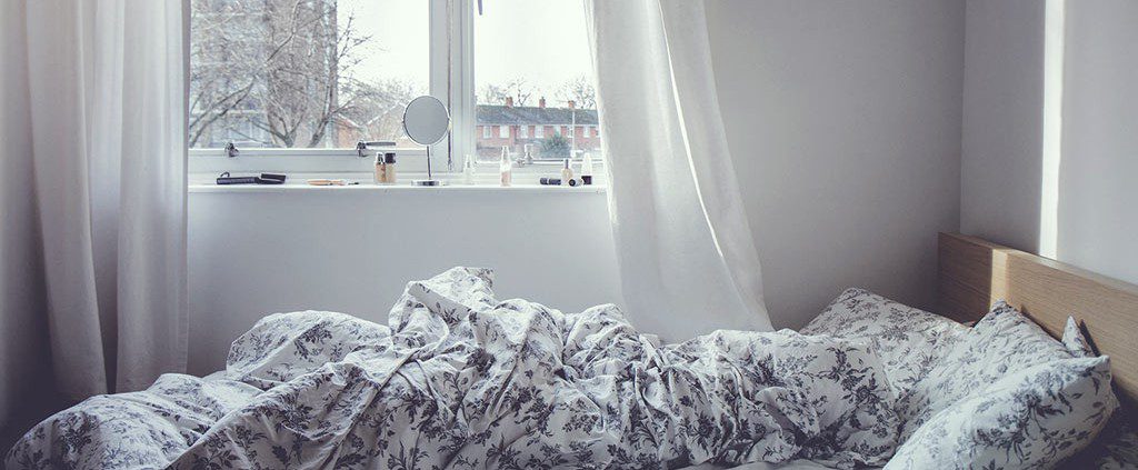 Unmade bed with floral sheets
