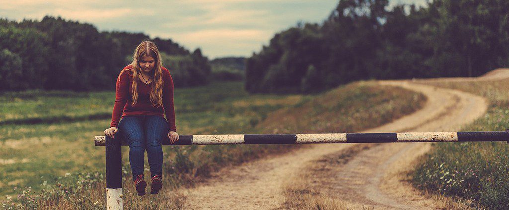 Girl sitting on railing thinking about fun things to do when you're single