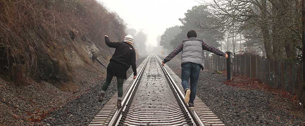Couple walking on railroad tracks