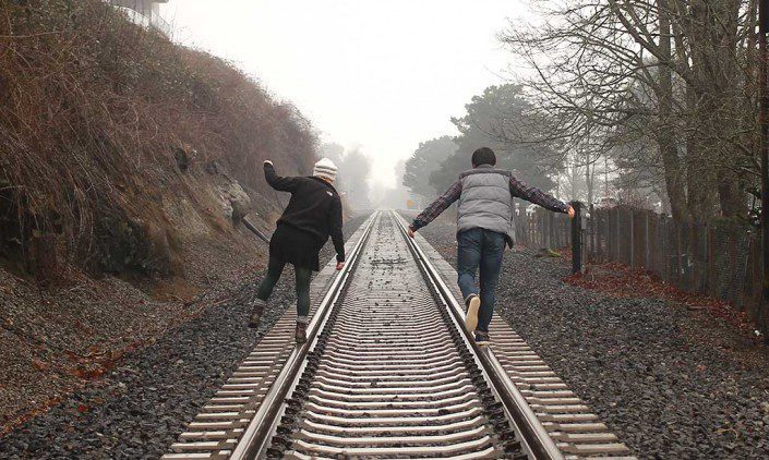 Couple walking on railroad tracks
