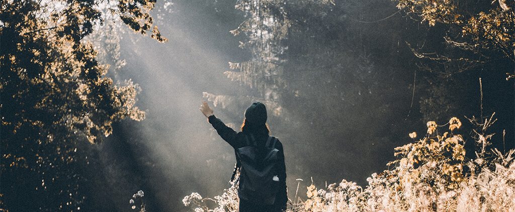 lady raising her hand to the sun's ray