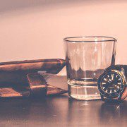 Watch, whiskey glass and wallet on the table - freedom from financial woes
