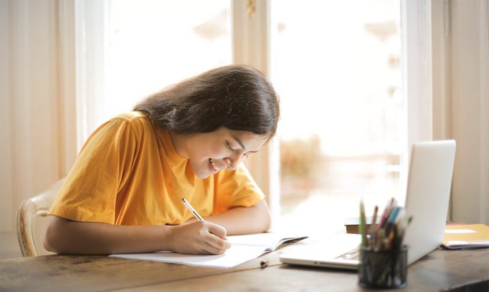 Image of girl writing in her notebook