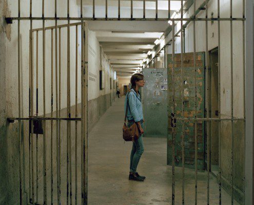 Girl standing in front of a prison cell