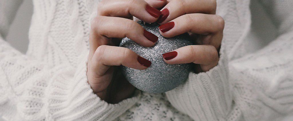 Woman holding a glitter Christmas ornament in her hands