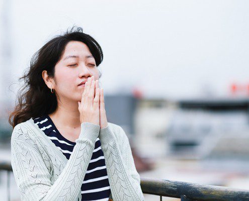 Woman standing alone praying