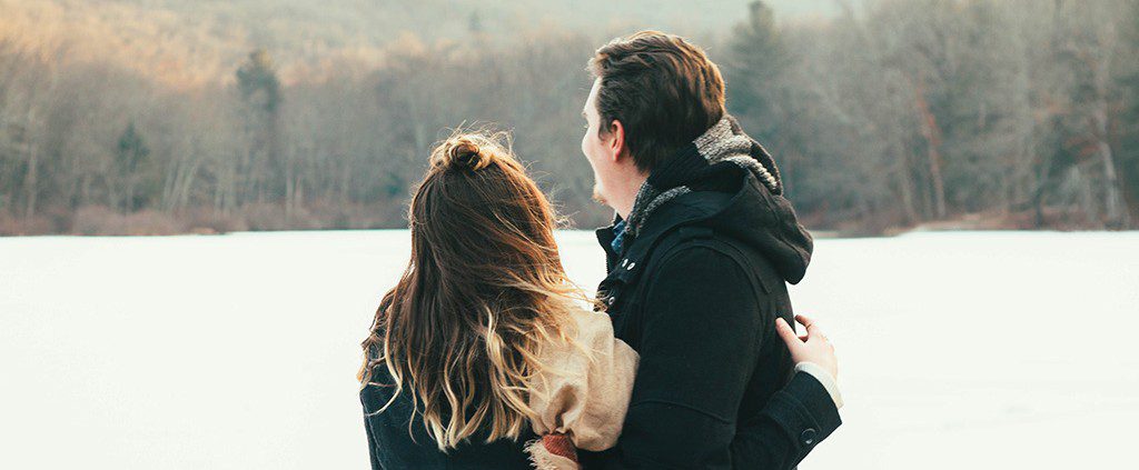 Couple embracing by a pond in the woods