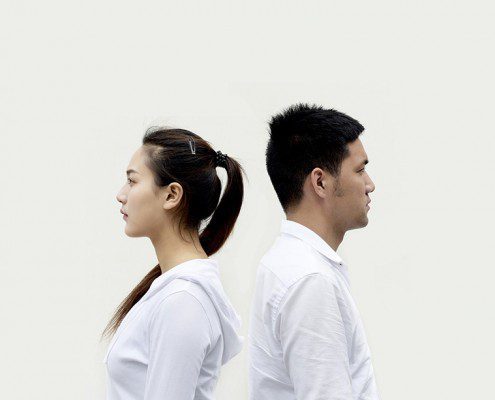 Couple standing back to back facing away from one another