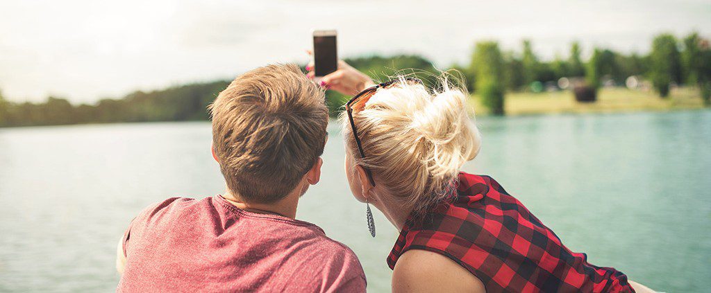 Couple taking a selfie together by the lake