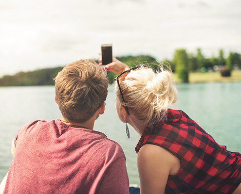Couple taking a selfie together by the lake