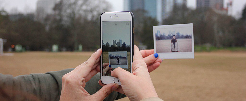 Photo of a polaroid - behind happy social media posts