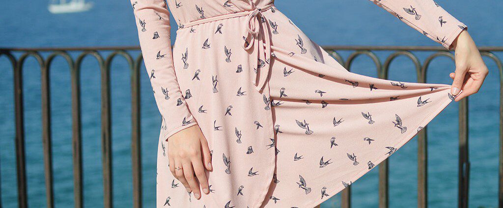 Woman wearing a pink dress with birds on it