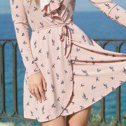 Woman wearing a pink dress with birds on it