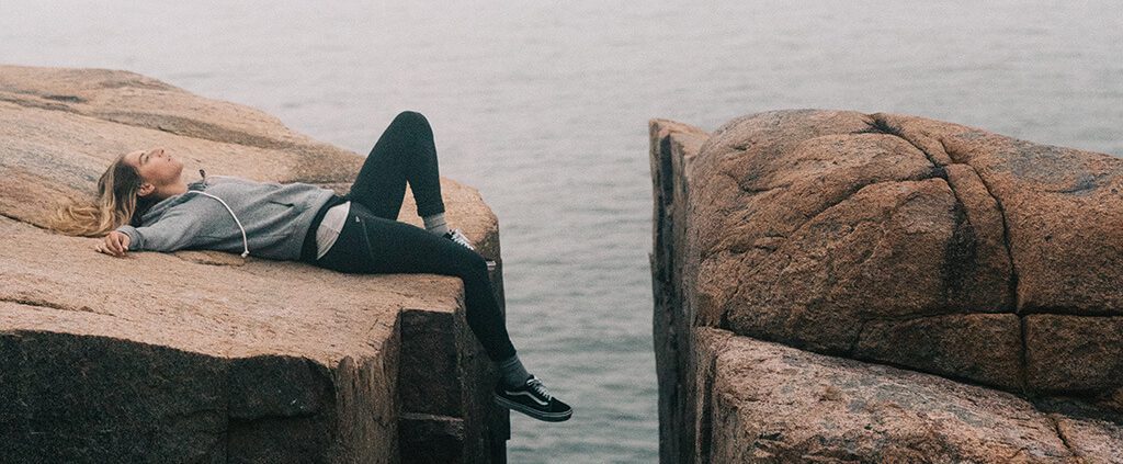 Woman lying down against a rock