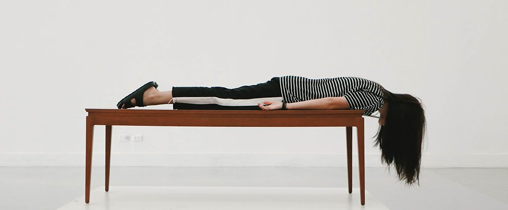 Girl lying flat on table - crossing the line of singleness