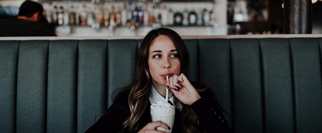 Girl sitting drinking a milkshake