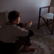 Man sitting on the ground sipping coffee