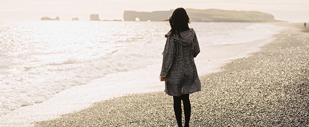 Woman standing alone on the beach reminiscing