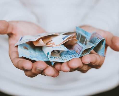 Hand holding dollar bills - stewardship is not just about money