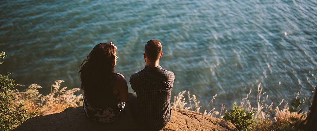 Couple sitting together above the water