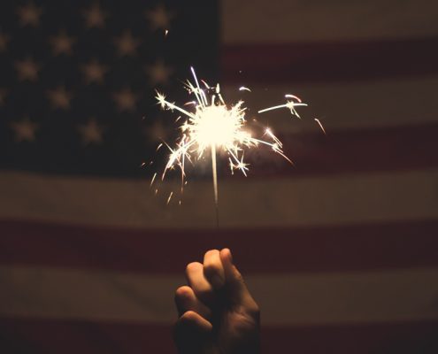 Sparkler being held in front of the USA flag