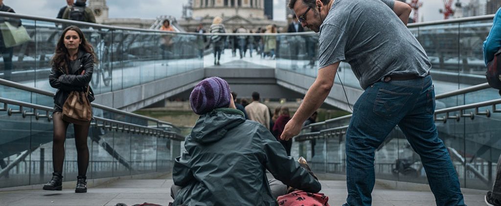 Man with his hand extended to a homeless person