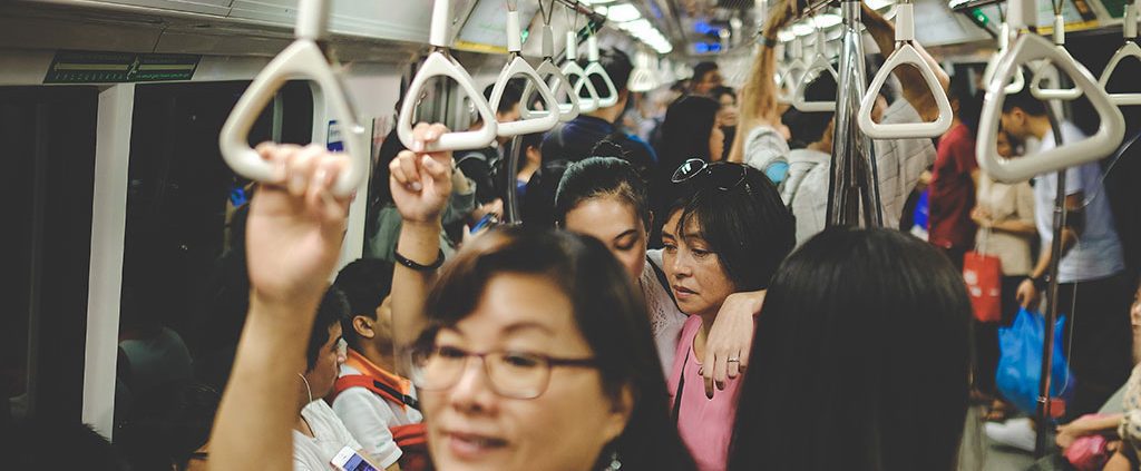 Group of people with their hands around each other on the train