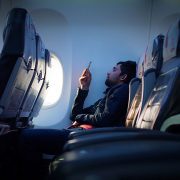 Man scrolling on his phone while flying