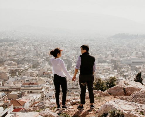 Couple holding hands looking over a city