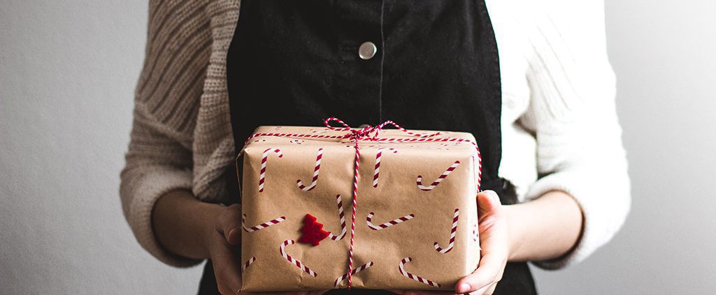 Woman standing holding a Christmas gift