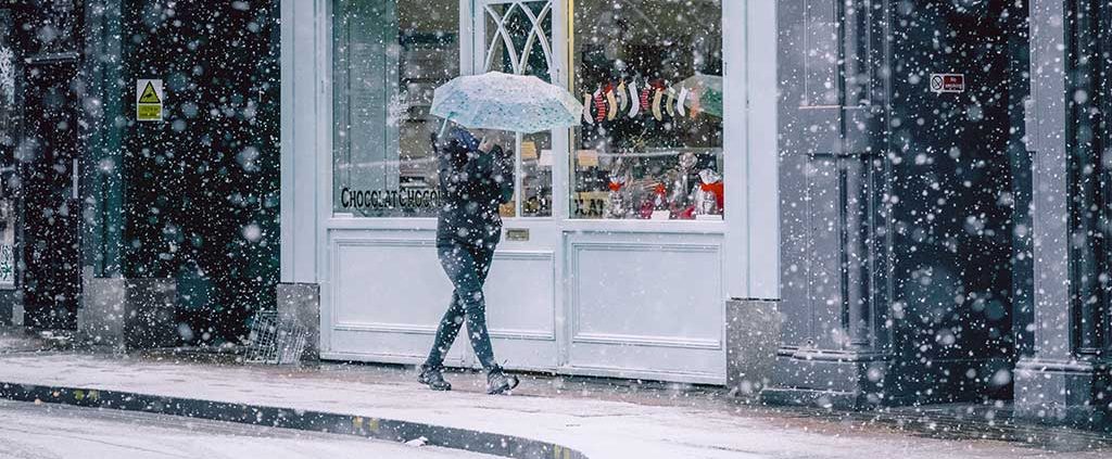 Woman walking with an umbrella in the snow