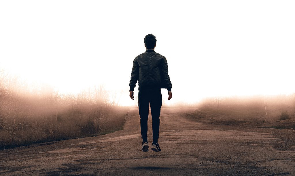 Man jumping up on an abandoned dirt road