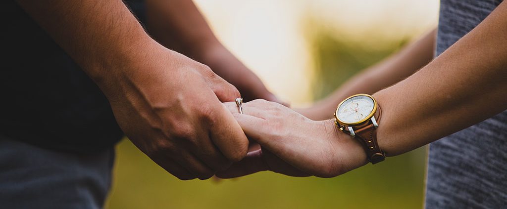 Couple facing each other holding hands