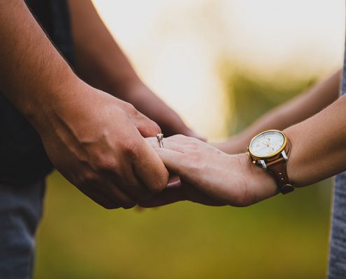 Couple facing each other holding hands