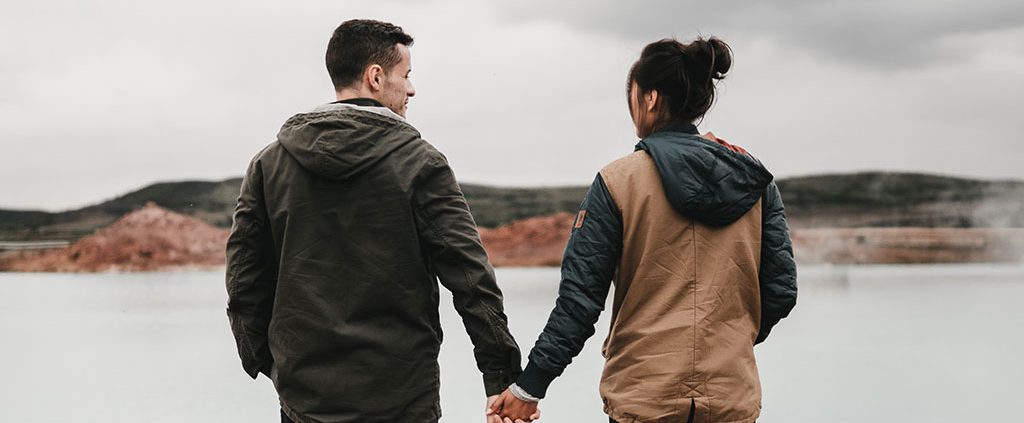 Couple holding hands overlooking a waterway