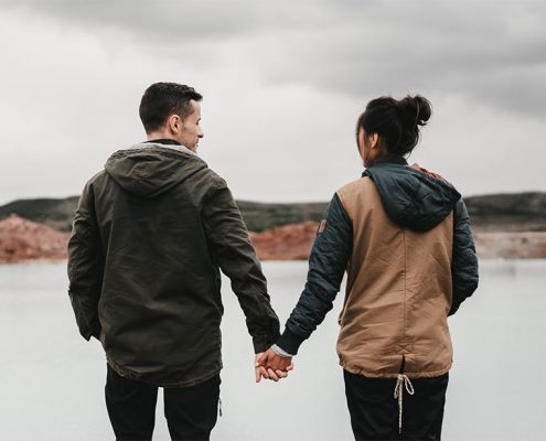 Couple holding hands overlooking a waterway