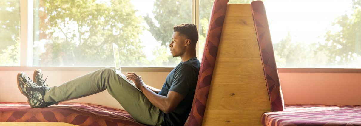 Student sitting using his laptop