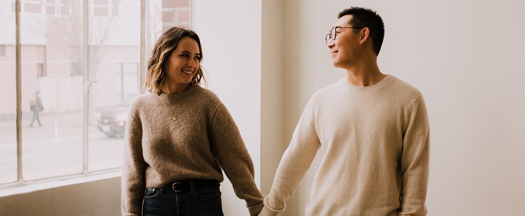 Couple holding hands in an empty apartment