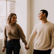 Couple holding hands in an empty apartment