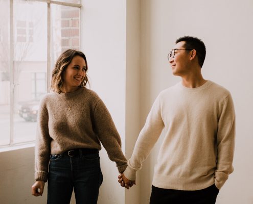 Couple holding hands in an empty apartment