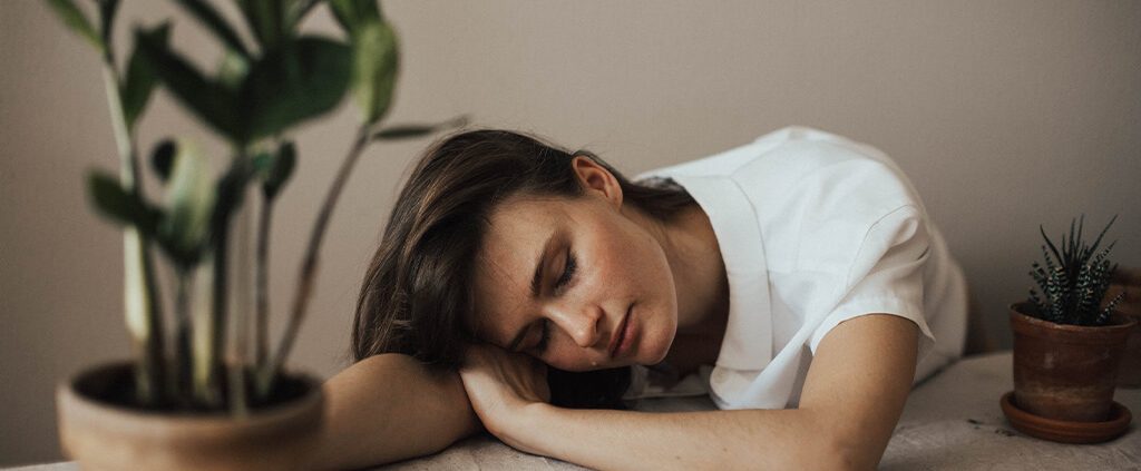 A woman feel bored on a table with some plants