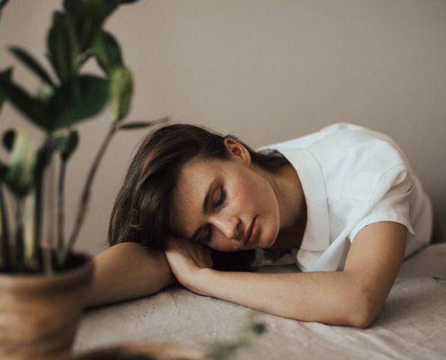 A woman feel bored on a table with some plants