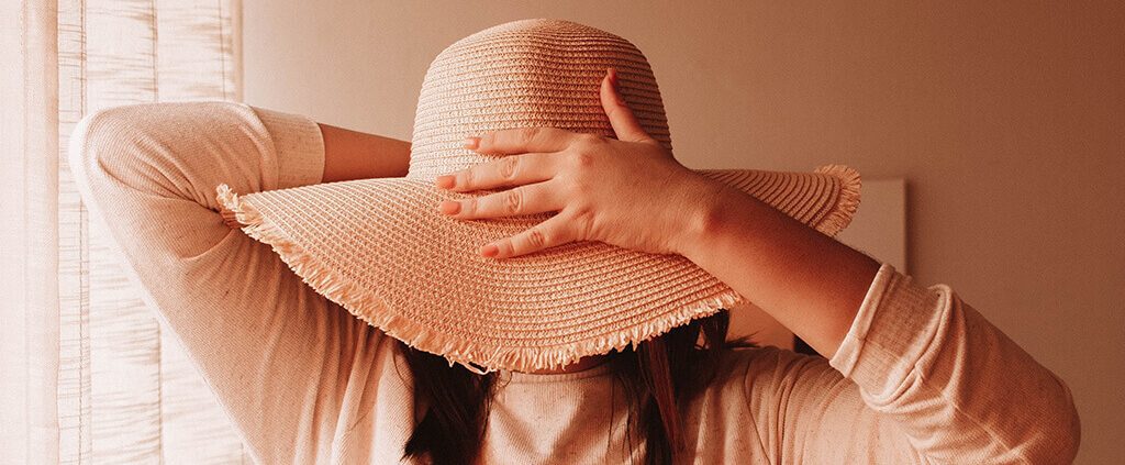 Image of a lady with her face covered by a sun hat