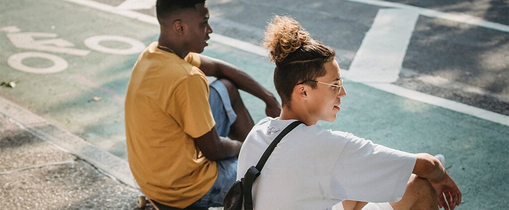 image of 2 men sitting by the road chatting