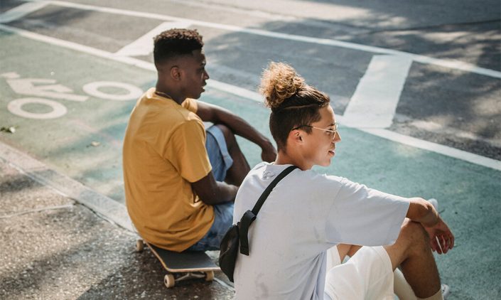 image of 2 men sitting by the road chatting