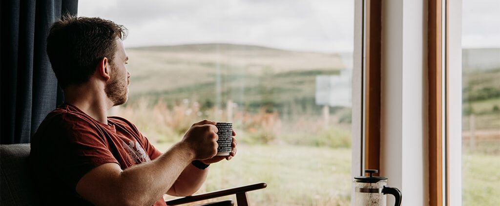 Image of a guy relaxing in front of a window