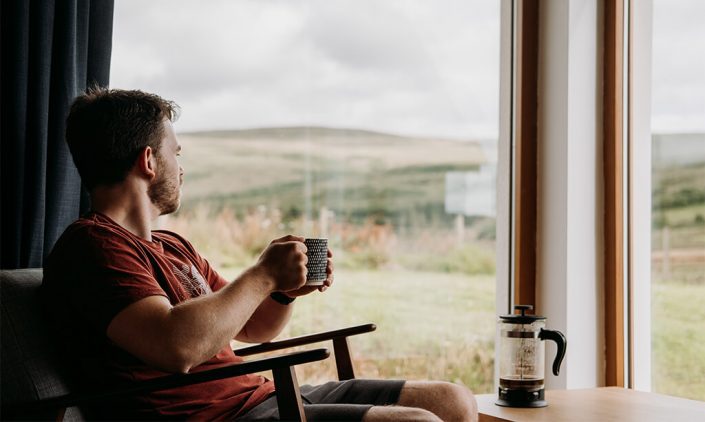 Image of a guy relaxing in front of a window